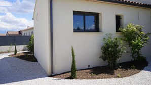 A modern house with a white exterior, a tiled roof, and a small window. - Cosy new house in Provence, terrace (PIOLENC)
