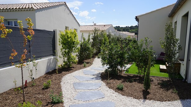 A pathway leading through a garden with a gravel surface and stepping stones. - Cosy new house in Provence, terrace (PIOLENC)