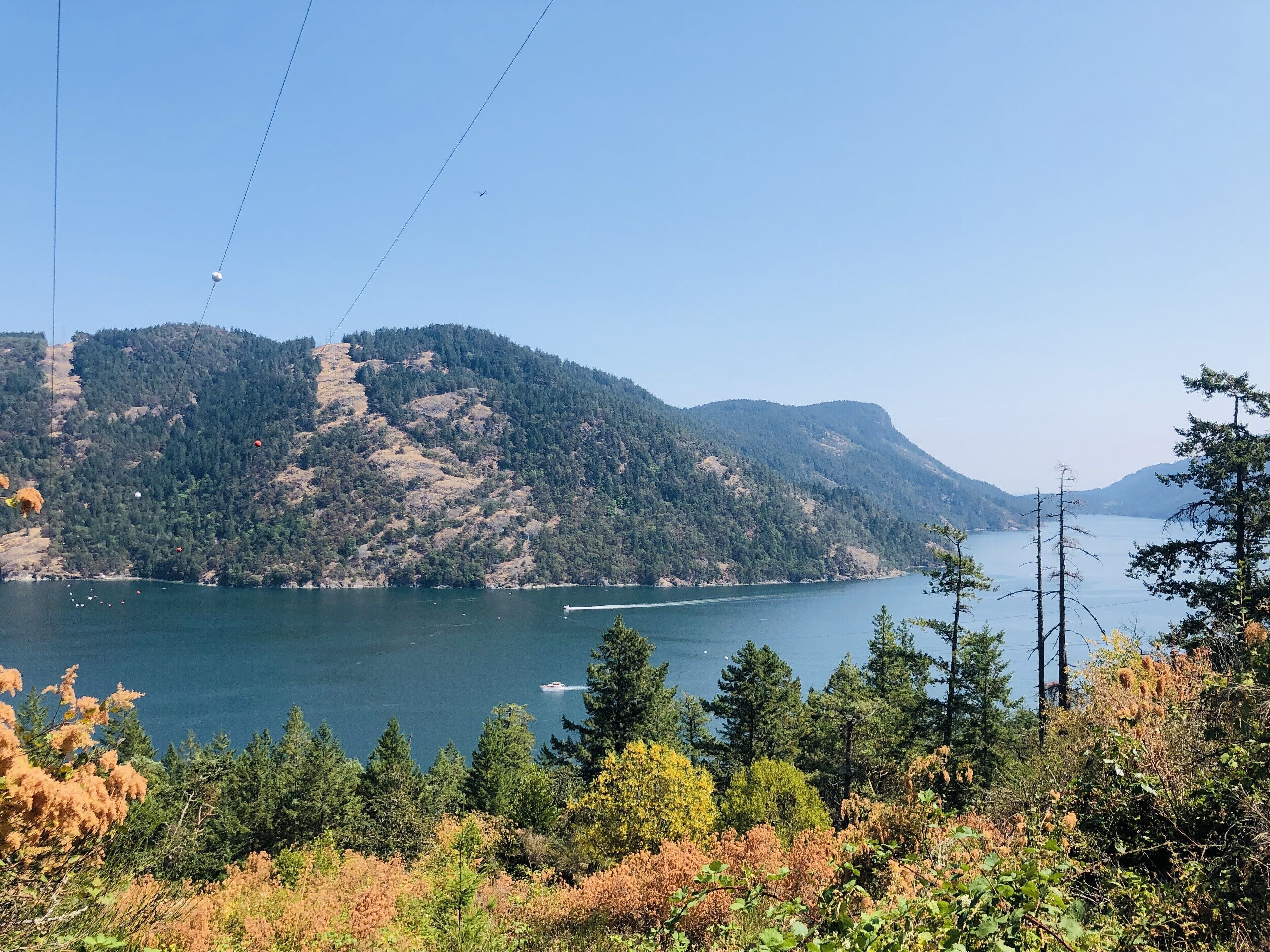 A lake surrounded by hills with a boat on the water.