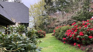 A well-maintained garden with a pathway leading to a house with a dark roof.