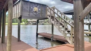 Una terraza de madera con una escalera que lleva a una zona cubierta con un logotipo.