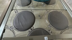 A glass-top dining table with four chairs, set in a modern room with a marble floor. - Crispi 2enty stylish flat at Spanish Steps (Roma)