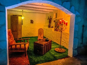 A cozy room with a wooden chair, a small table with a teapot, and a suitcase.