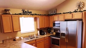 A kitchen with wooden cabinets, a stainless steel refrigerator, an oven, and a microwave. - 2 Bedroom  Cabin inside Pigeon Forge (Pigeon Forge)