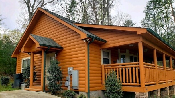 A log cabin with a porch and a stone foundation. - 2 Bedroom  Cabin inside Pigeon Forge (Pigeon Forge)
