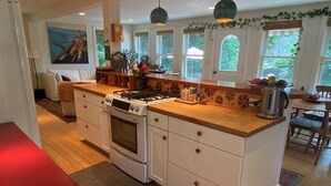 Una cocina moderna con armarios blancos, estufa a gas y una isla grande.