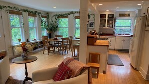 Un salón amplio con sofá, una mesa de comedor con sillas y una zona de cocina con armarios y fregadero.