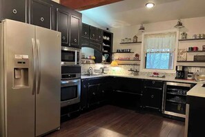 Enjoy cooking in this well-equipped kitchen with a refrigerator, oven, and dishwasher, plus a convenient window with an outdoor view.