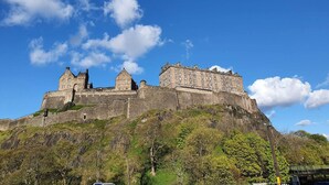 A historic castle on a hill with a clear sky. - Lovely 2 Bedroom Flat in the Heart of the City (Edinburgh)
