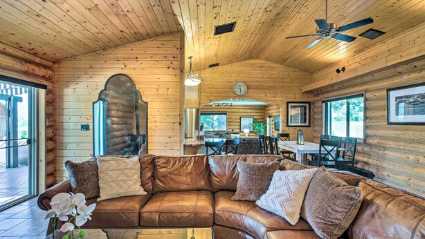Un intérieur de chalet chaleureux avec un canapé en cuir, des murs en bois et un coin repas.