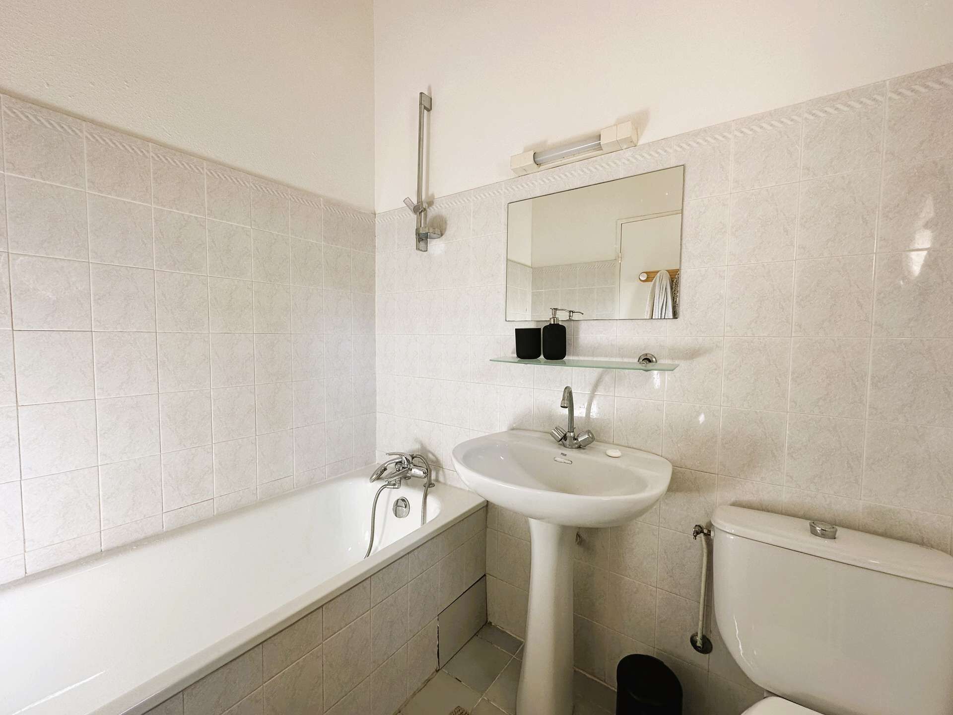 A modern bathroom with a bathtub, a sink, and a toilet.