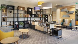 Un interior moderno con un sofá seccional, una mesa de centro y una estantería llena de objetos decorativos.