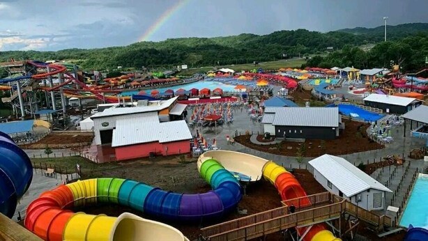 Parque acuático con múltiples toboganes y un arcoíris.