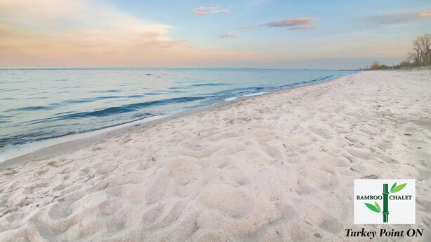 A beach with a logo for Bamboo Chalet and Turkey Point ON. - Summer Beach Family Cottage  🏖 2min→beach @ Bamboo Chalet ~ Lake Erie 🇨🇦 
 (Turkey Point)