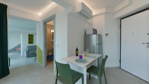Een ruimtelijk ingerichte leefruimte met een eethoek, een kitchenette en een aparte badkamer.