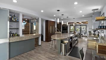 A modern kitchen with a central island, bar area, and built-in wine storage.