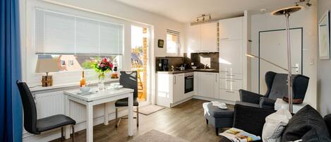 A modern apartment with a dining area, kitchen, and living room.