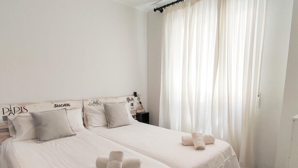 A hotel room with two beds, white linens, and a grey bench. - Sun Terrace Penthouse Living4malaga (Málaga)