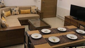 Un salon moderne avec un canapé, une table basse et une table à manger pour quatre personnes.