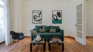 A modern living room with a green sofa, two black coffee tables, and abstract art on the wall. - 3Bdr Modern Design & Bright Interiors in Plaka (Athens)