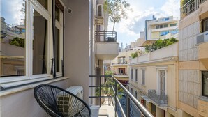 A balcony with a chair, a railing, and a view of neighboring buildings. - 3Bdr Modern Design & Bright Interiors in Plaka (Athens)