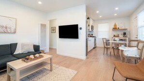 A modern apartment with a living room, kitchen, and dining area.