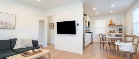 A modern apartment with a living room, kitchen, and dining area.