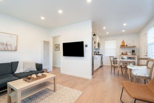 Un appartement moderne comprenant un salon, une cuisine et un coin repas.