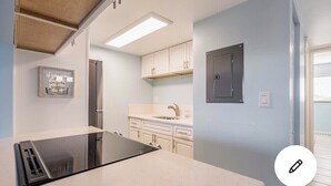 A modern kitchen with white cabinets, a black countertop, and a built-in oven.