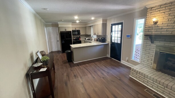 A spacious kitchen with a central island, a fireplace, and a view of the backyard.