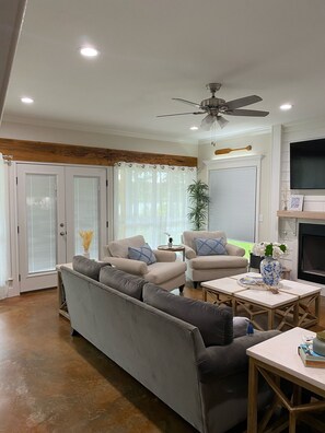 Relax in this stylish living room with a fireplace, flat-screen TV, and comfortable seating for two.