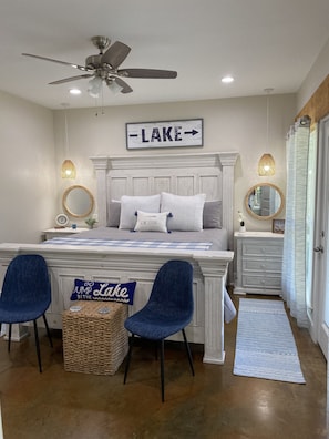 Relax in this serene bedroom with a central bed, desk, and comfortable seating areas.