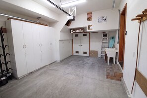 A room with a kitchenette, a sign for 'Cocktails', and a snowboard sign. - Hideaway Down Canyon #110, End Unit close to June Mtn (June Lake)