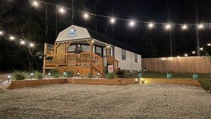 A wooden house with a porch, string lights, and a sign reading "The Lilypad."