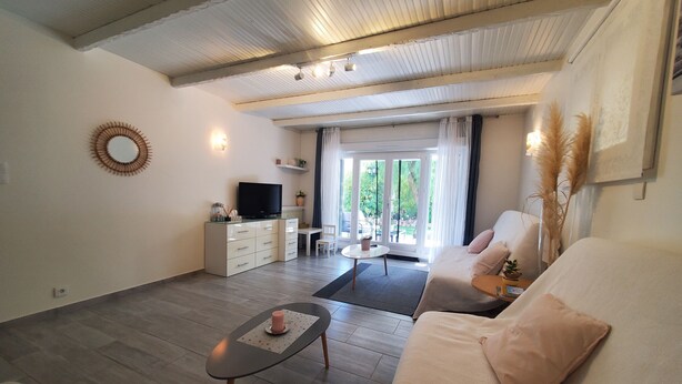 A modern living room with a sofa, a coffee table, a TV, and a dining area with a table and chairs. - MAGNIFICENT T2 58m2 air-conditioned PORT FREJUS 4/5 P in residential area, terrace, quiet and close to everything (Fréjus)