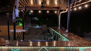 Ein Holzterrasse mit Barbereich, einem Rettungsringschild und einem Schild mit dem Gründungsjahr.