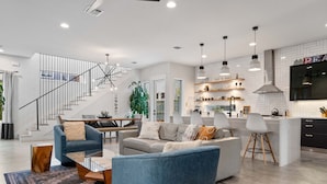 Una sala de estar moderna con un sofá, una mesa de centro y una escalera que lleva a un nivel superior.