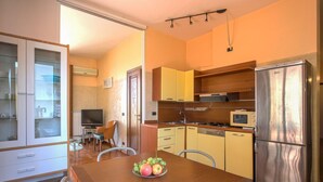 A compact kitchen with a dining table, a refrigerator, and a microwave. - Nanà - Sweet Dreams in Florence (Firenze)