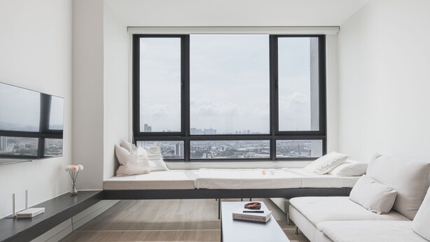 A modern living room with a large window, a sofa, a coffee table, and a flat-screen TV. - Greenfield Residence at Bandar Sunway (Petaling Jaya)