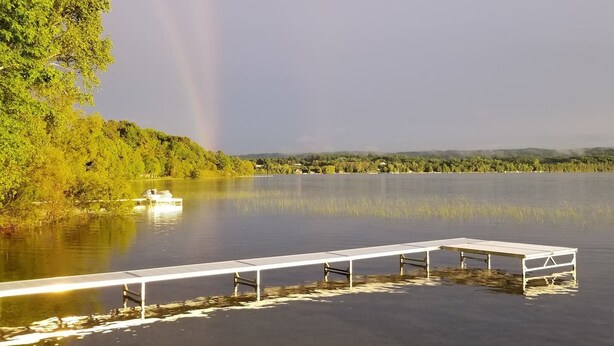 Vista con lago, un muelle y un bote.