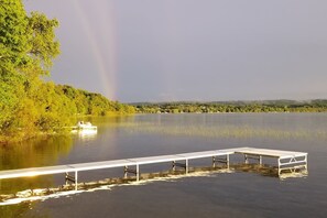A lakeside view with a dock and a boat.