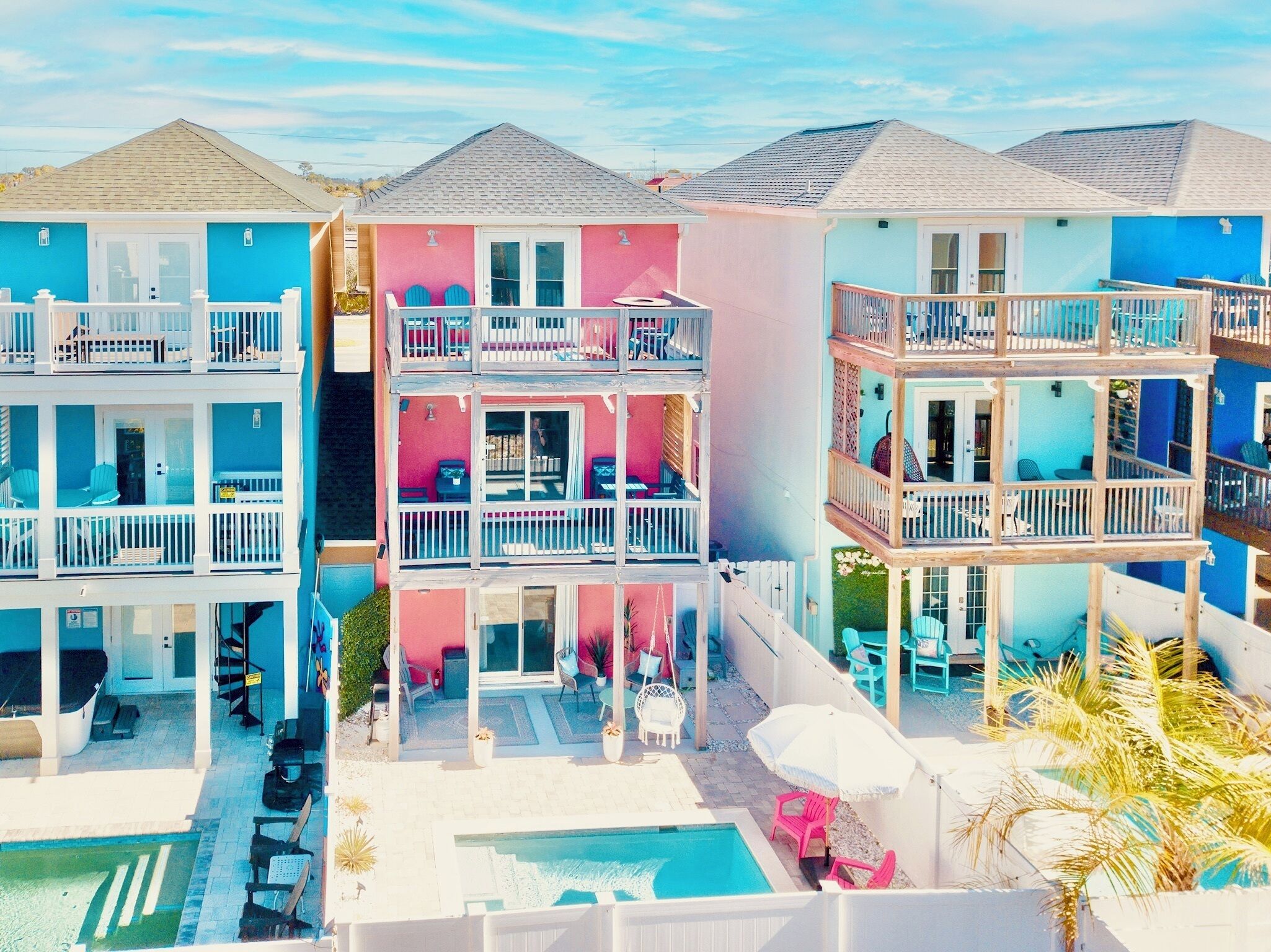 A multi-story hotel with balconies, a swimming pool, and outdoor seating areas.