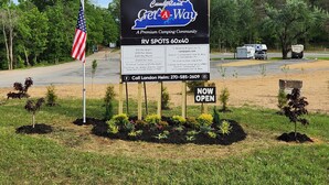 A campground sign advertising RV spots and camping rates. - Camper on campsite (Jamestown)