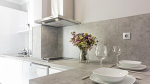 A modern kitchen with a built-in dishwasher, a stainless steel range hood, and a marble countertop. - Malaga Center Flat - SoHo Center Apartments Superior (Málaga)