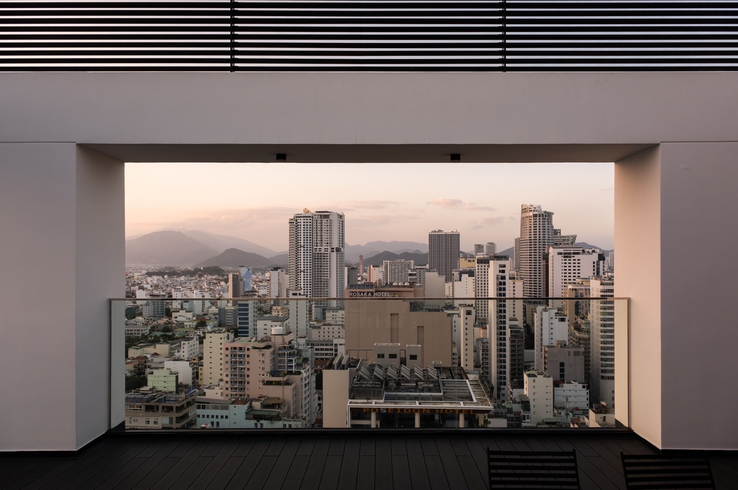 Um hotel moderno com vista panorâmica da cidade, com edifícios notáveis como o Hotel Rosaka e o Hotel Poseidon.