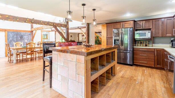 A spacious kitchen with wooden cabinets, a central island, and stainless steel appliances.
