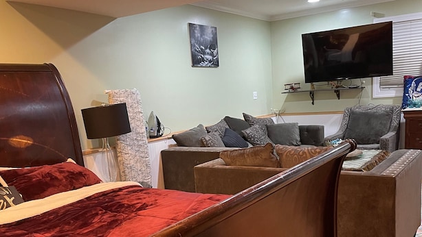 Una habitación de hotel con una cama, dos sillones, un sofá, un televisor y un ventilador de techo.