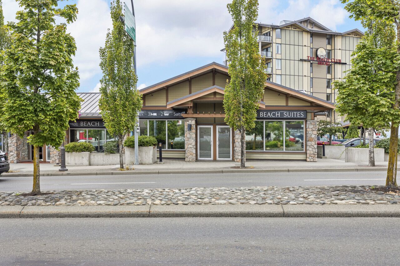 A hotel with a stone facade, labeled "Beach Suites," and a sign for "The Mac Club."