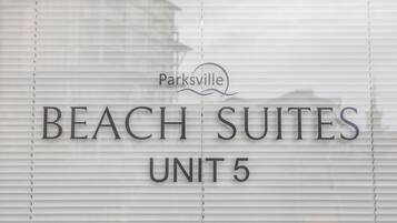A sign for 'BEACH SUITES UNIT 5' with a logo above it.
