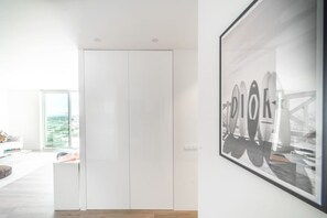 Ein modernes Interieur mit Schiebetürenschrank, einem gerahmten Bild an der Wand und Blick durch eine Glastür.